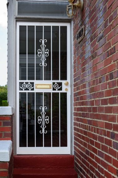 white allegro security door on brick house