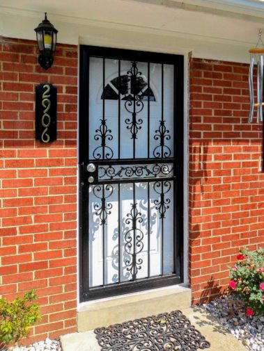 black spanish scroll security door on brick house