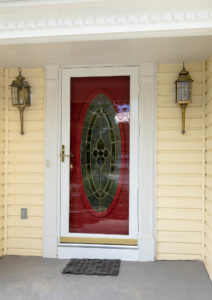 picture showing aluminum storm door construction on a yellow house