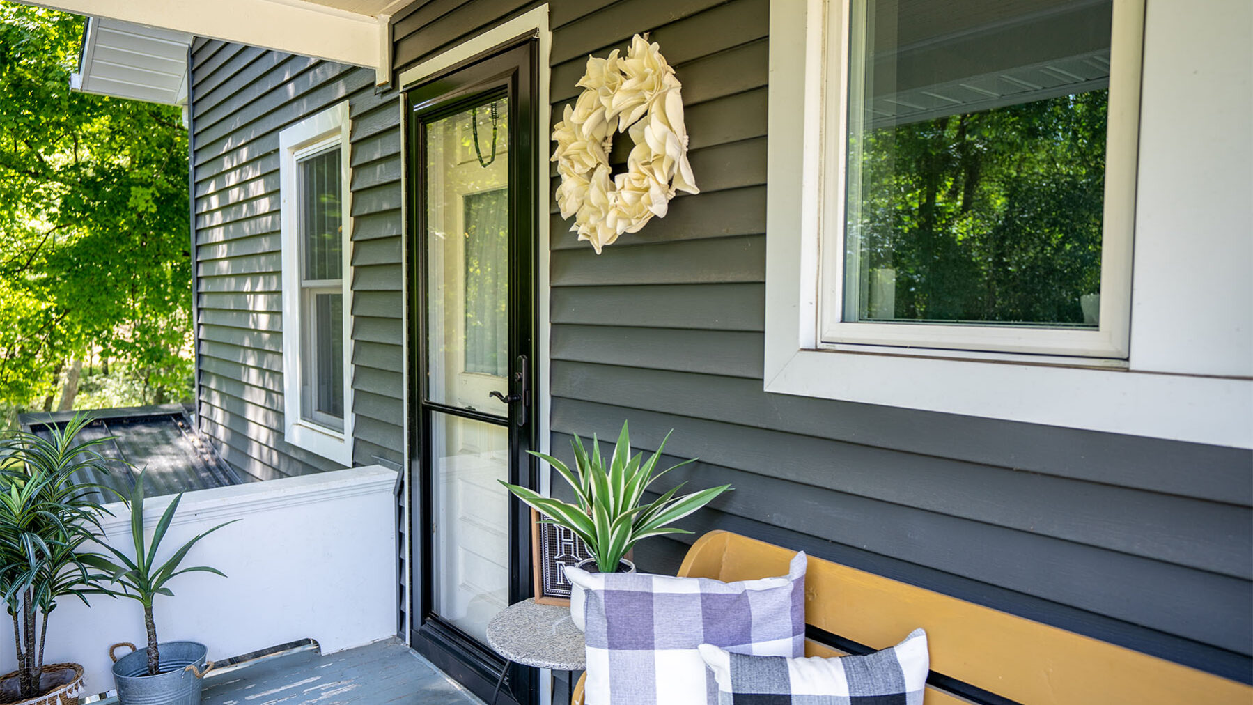 Side view of rust-free metal storm door on neatly decorated porch