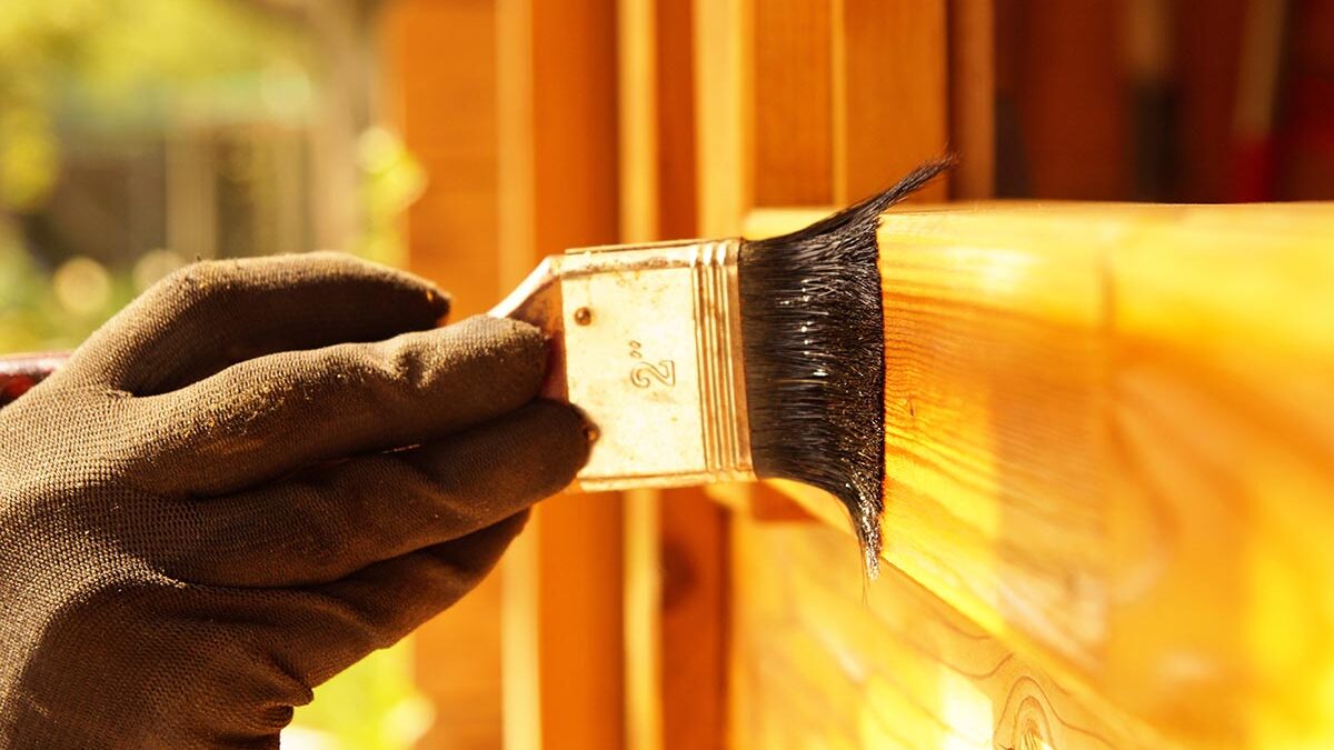 a brush applies fiberglass door stain