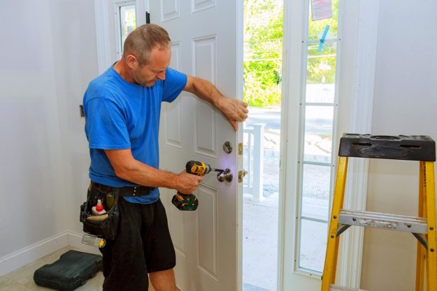 How to Choose a Door Installation Company a person installs a door for a door installation company