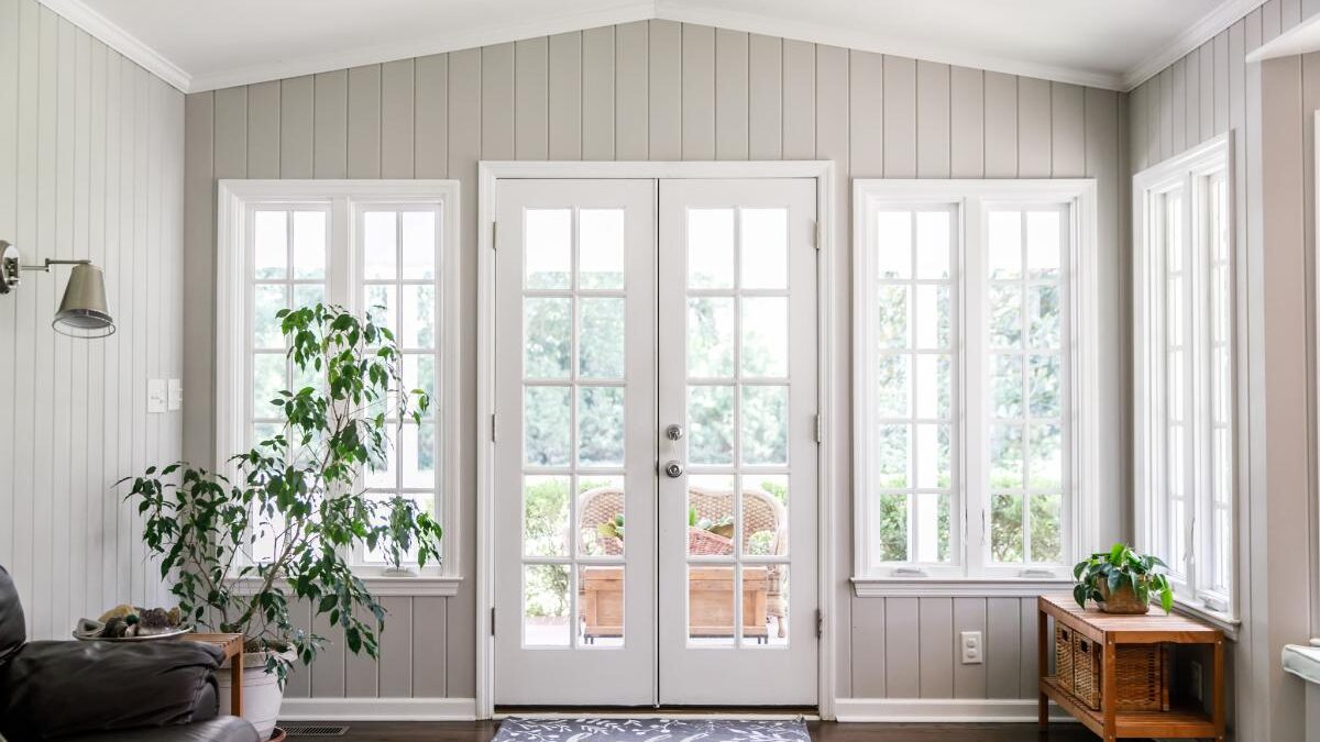 A beautiful and airy living room space with wide windows and natural light is secured from drafts by DIY draft stoppers for doors