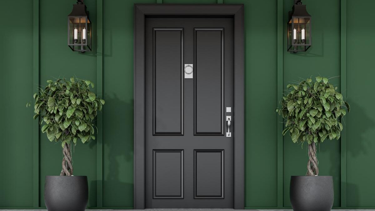 A beautiful entryway with a black door framed by green walls after the Door Pros helped choose your front door