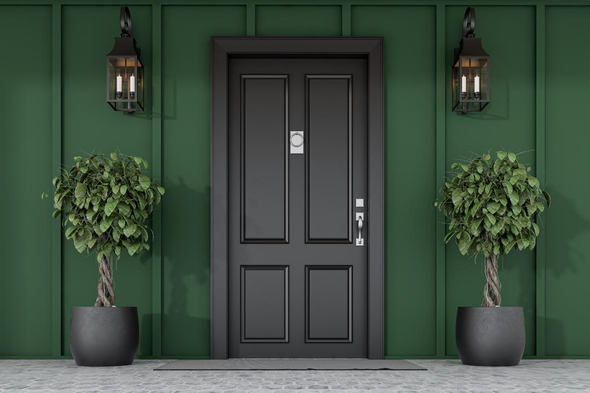 How to Choose the Right Front Door for Your Home A beautiful entryway with a black door framed by green walls after the Door Pros helped choose your front door