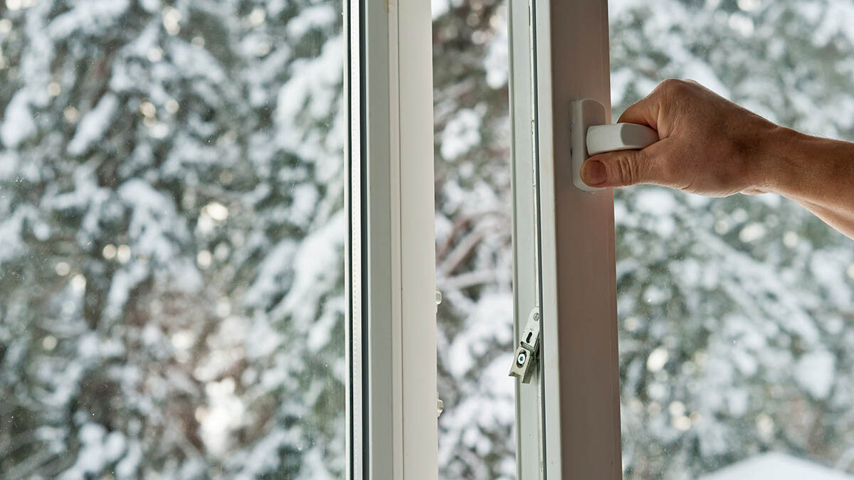 a person with a view of snowy trees displays their clean vinyl windows