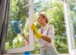 a person cleaning their windows while using home remedies to remove rust