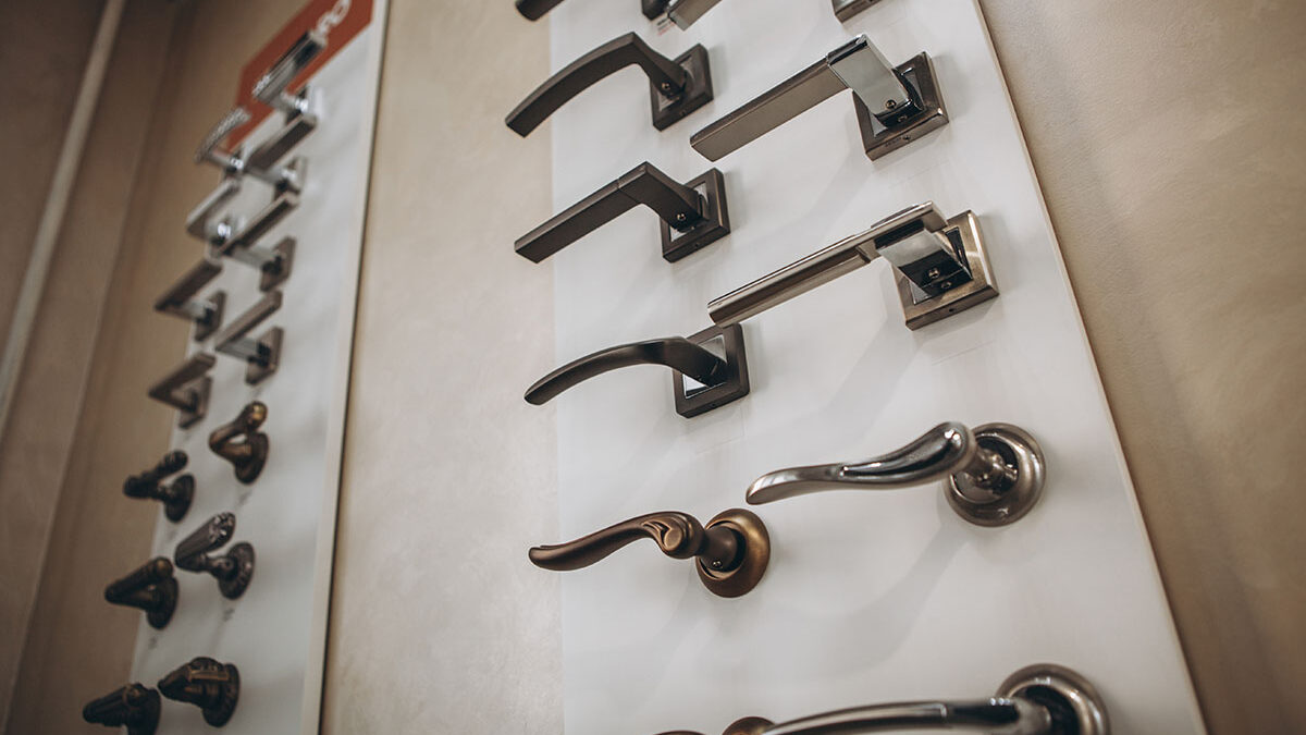 a long display case of door handles showing exterior door hardware