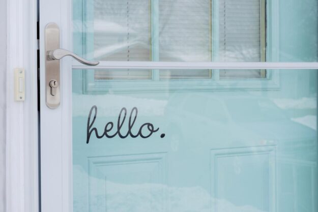 What to Think About Before Your Storm Door Replacement a newly replaced storm door with a hello decal