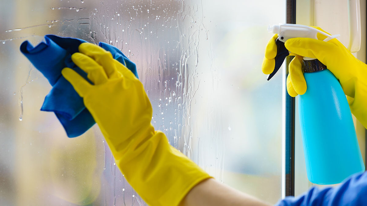 a person cleans windows with streak free cleaner