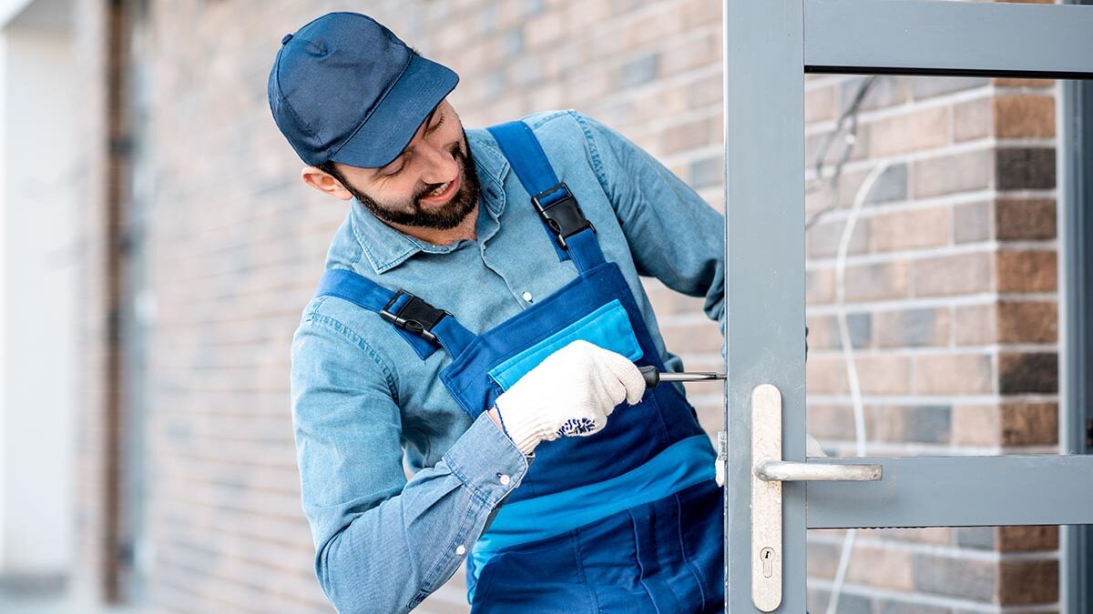 a professional installs commercial doors on a building