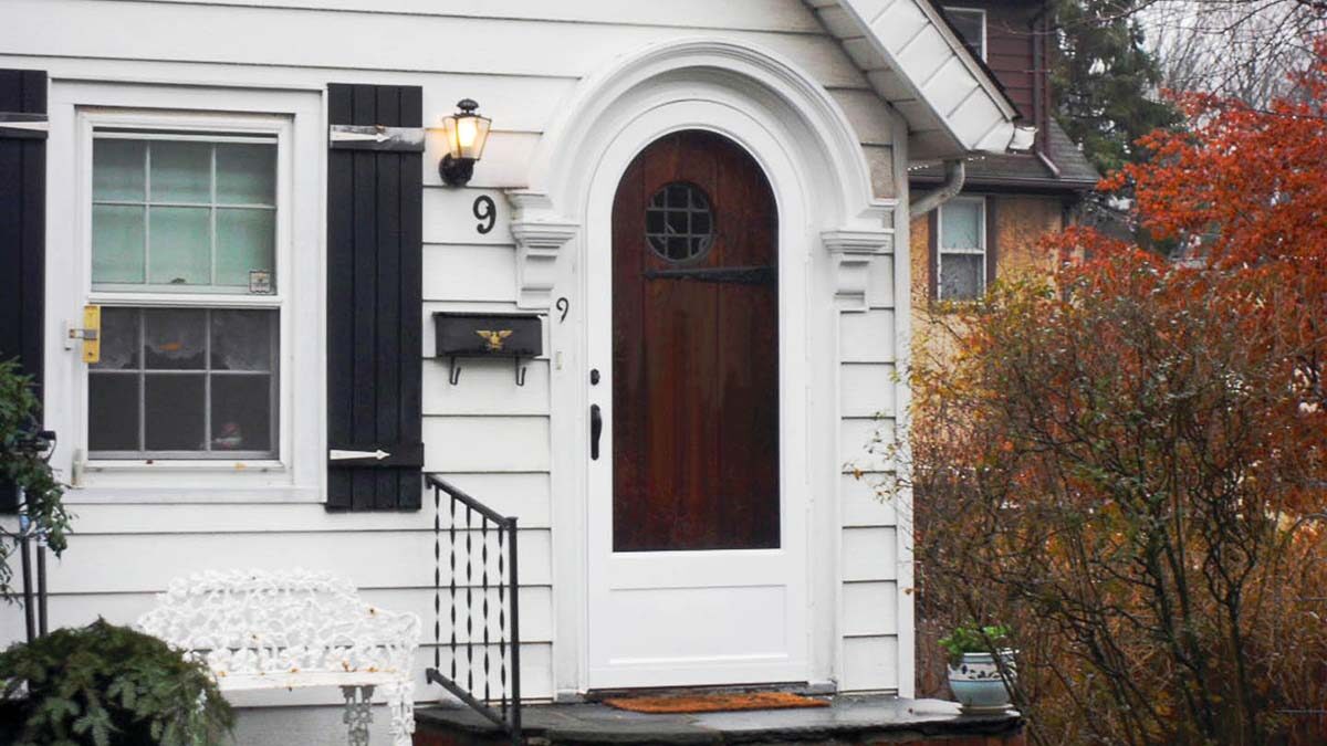 front facade of a house with an arched aluminum door