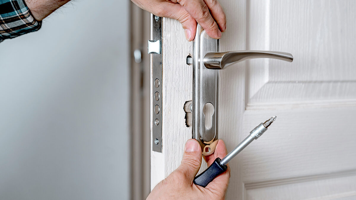 Finding-Door-Replacement-Services-In-Baltimore,-MD a person works on a door handle after a customer ordered a door replacement in baltimore md