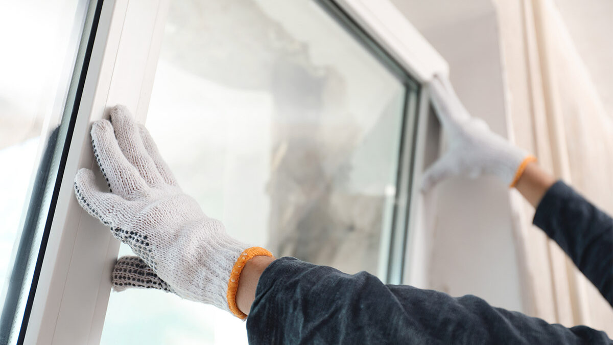 a professional installs new windows in a home