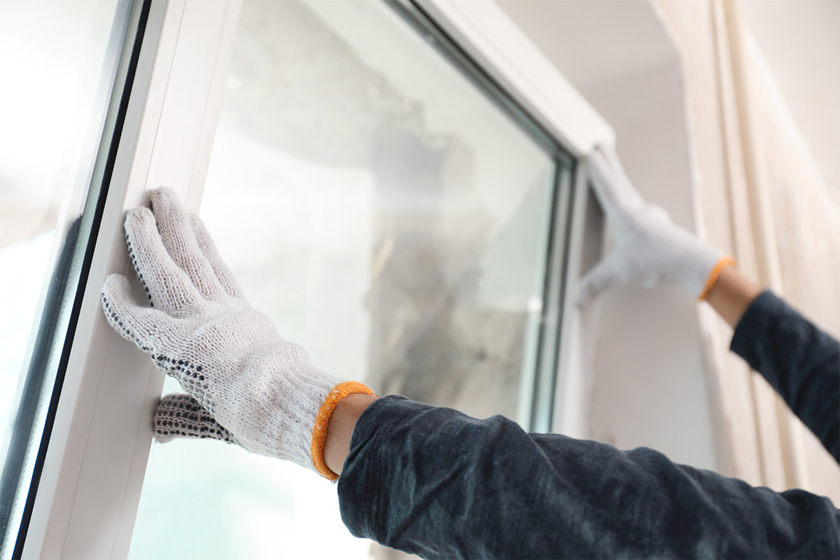 How New Window Installation Can Boost Your Home’s Energy Efficiency a professional installs new windows in a home