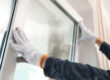 a professional installs new windows in a home