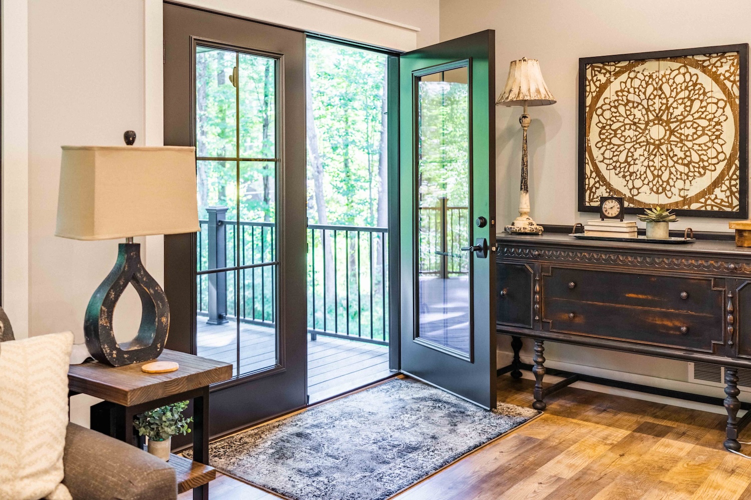 Choosing the Best Door Thresholds for Your Home A Comprehensive Guide Living room interior with black French doors opening to a wooded deck.