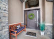 gray front door with sidelights on a tan house