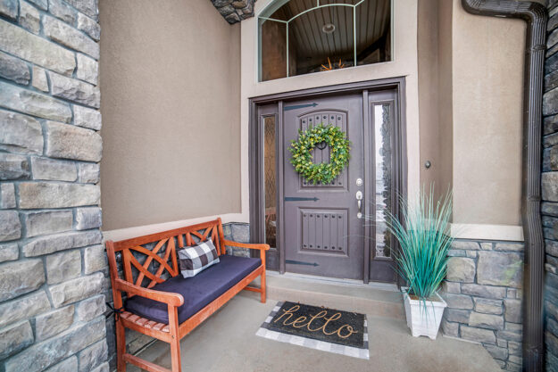 gray front door with sidelights on a tan house