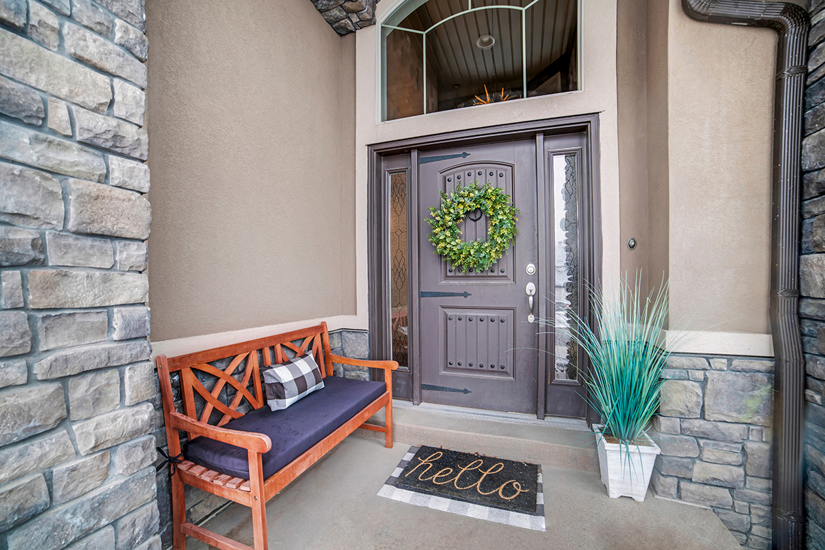 gray front door with sidelights on a tan house