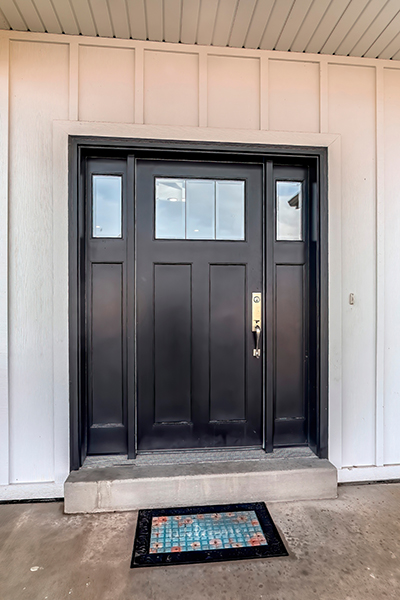 black front door on a white exterior with sidelights