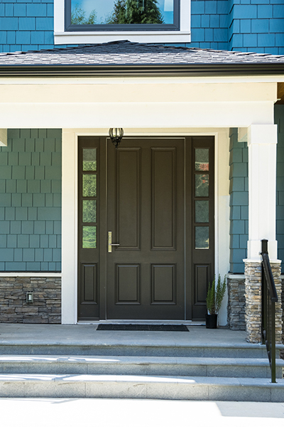 black steel door on a blue house with sidelights