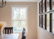 White-framed window bringing natural light into a dining room