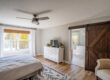 Bedroom with a large window framed by white curtains